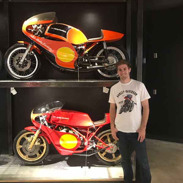 Andy DiBrino at Barber Motorcycle Museum standing with some classic motorcycles he'd like to throw a leg over 