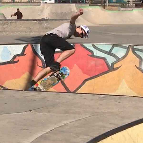 Andy shredding on a skateboard at a skate park caught in air