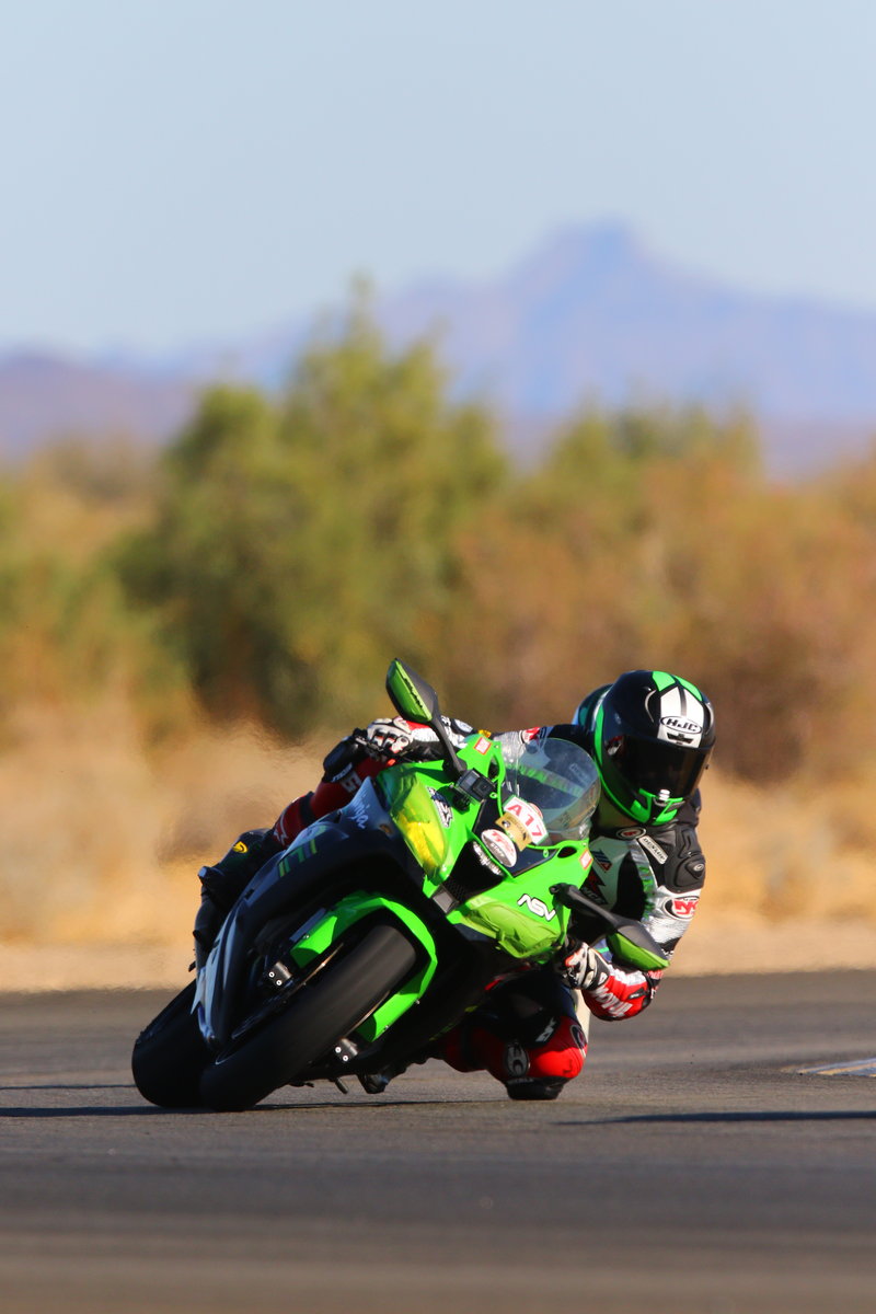 Andy DiBrino on his 1000cc Kawasaki EDR Performance beast of a track day motorcycle with 187 horse power leaning hard in a turn training Chuckwallla Valley Raceway