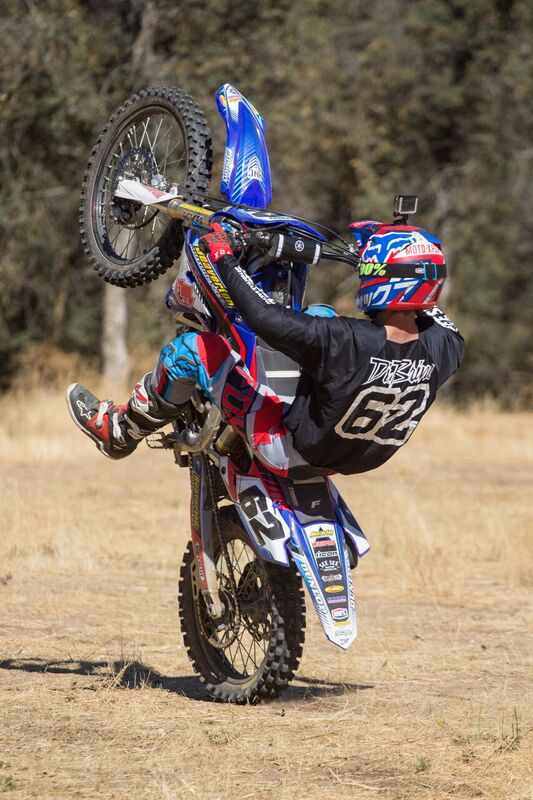 pictured Andy Dibrino number 62 popping a wheely on his motocross bike 