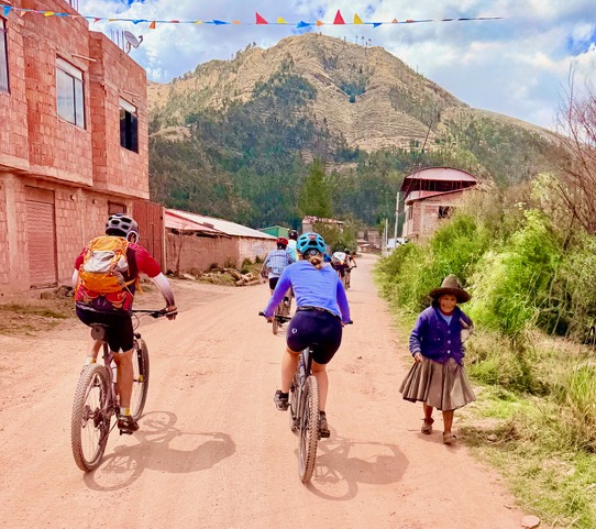 Peru gravel camp bicycle attorney cycling team riding through a village on a quiet dirt road on a long ride through many spectacular vistas